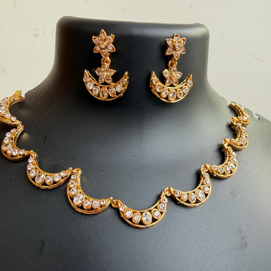 Gold crescent moon and star jewelry set with rhinestone embellishments, displayed on a black mannequin bust.
